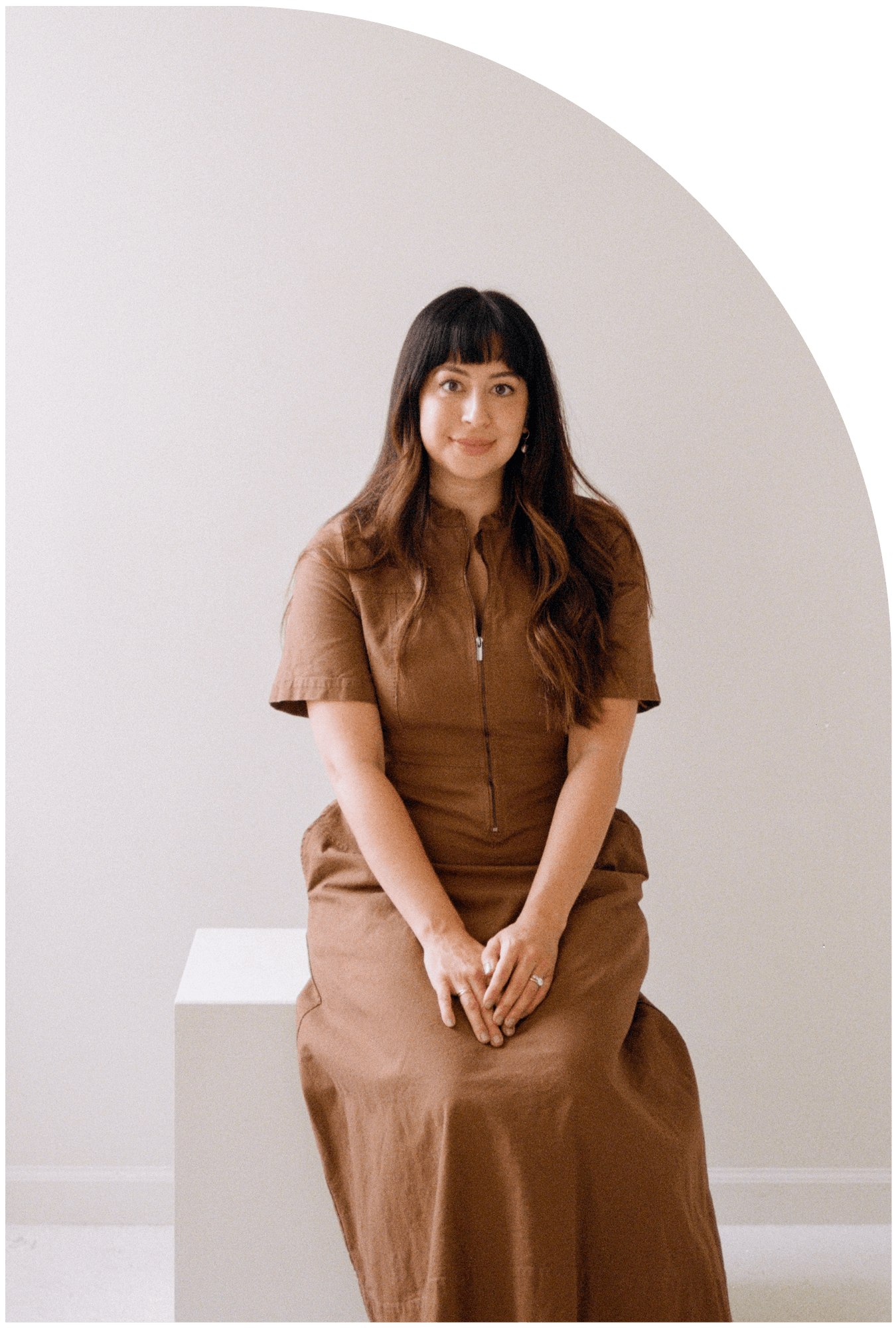 Amalia Miralrio sits on cube looking at camera