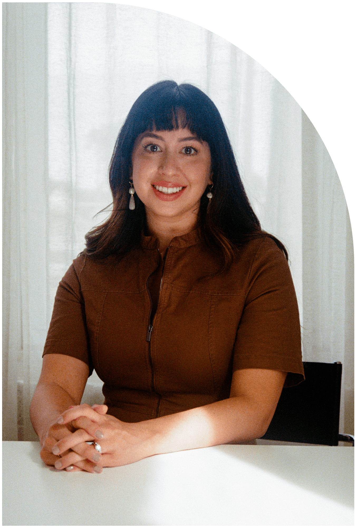 therapist sitting at desk with hands crossed