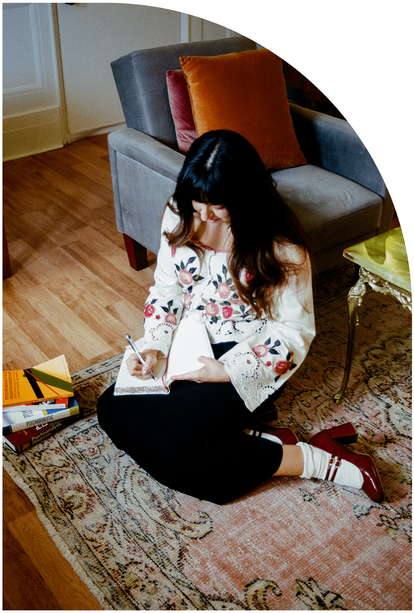 therapist sits on floor writing