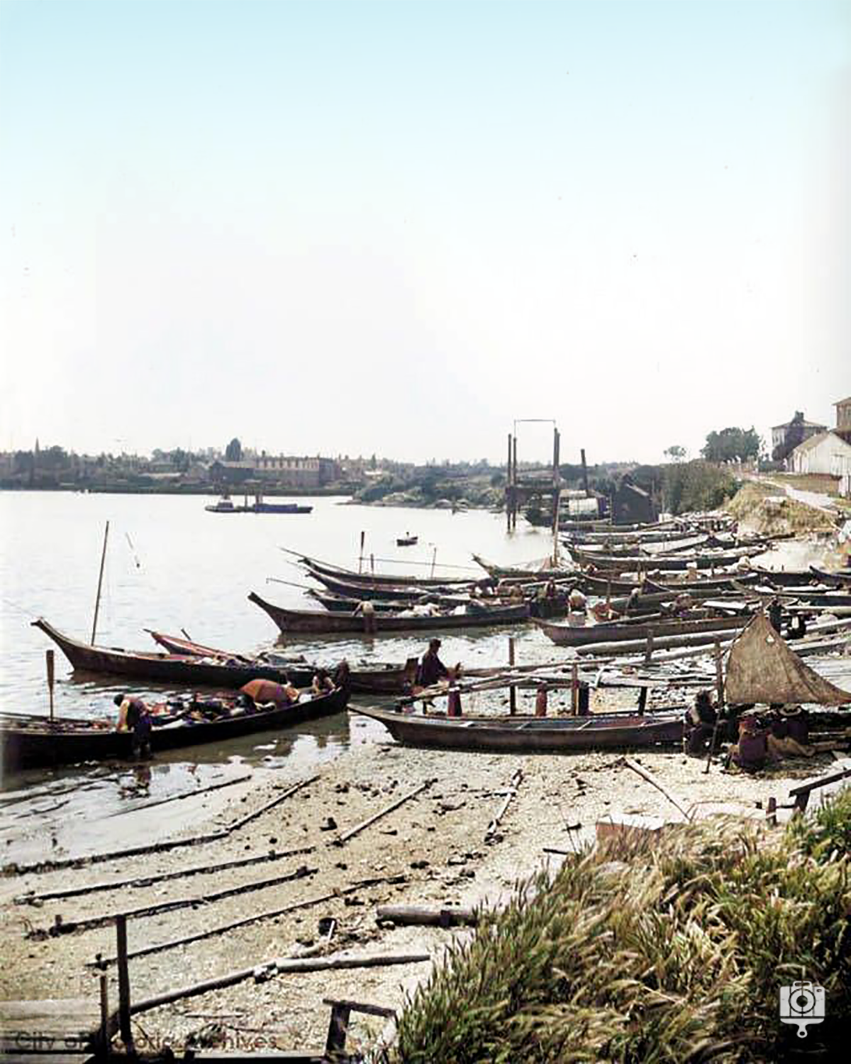 First Nations canoes pulled up on the beach of the Songhees reserve, Laurel Point centre in background, ca 1900