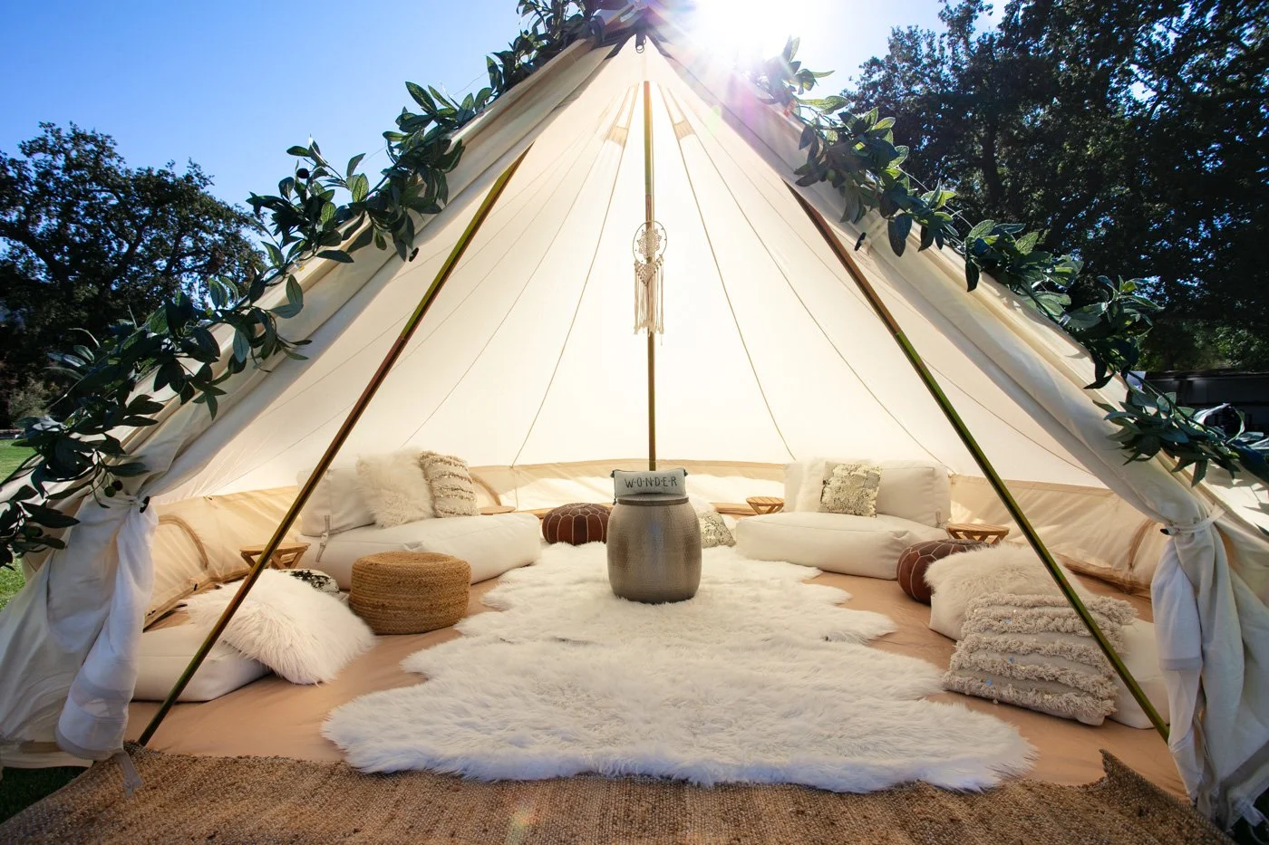 A large bell tent with couches and pillows