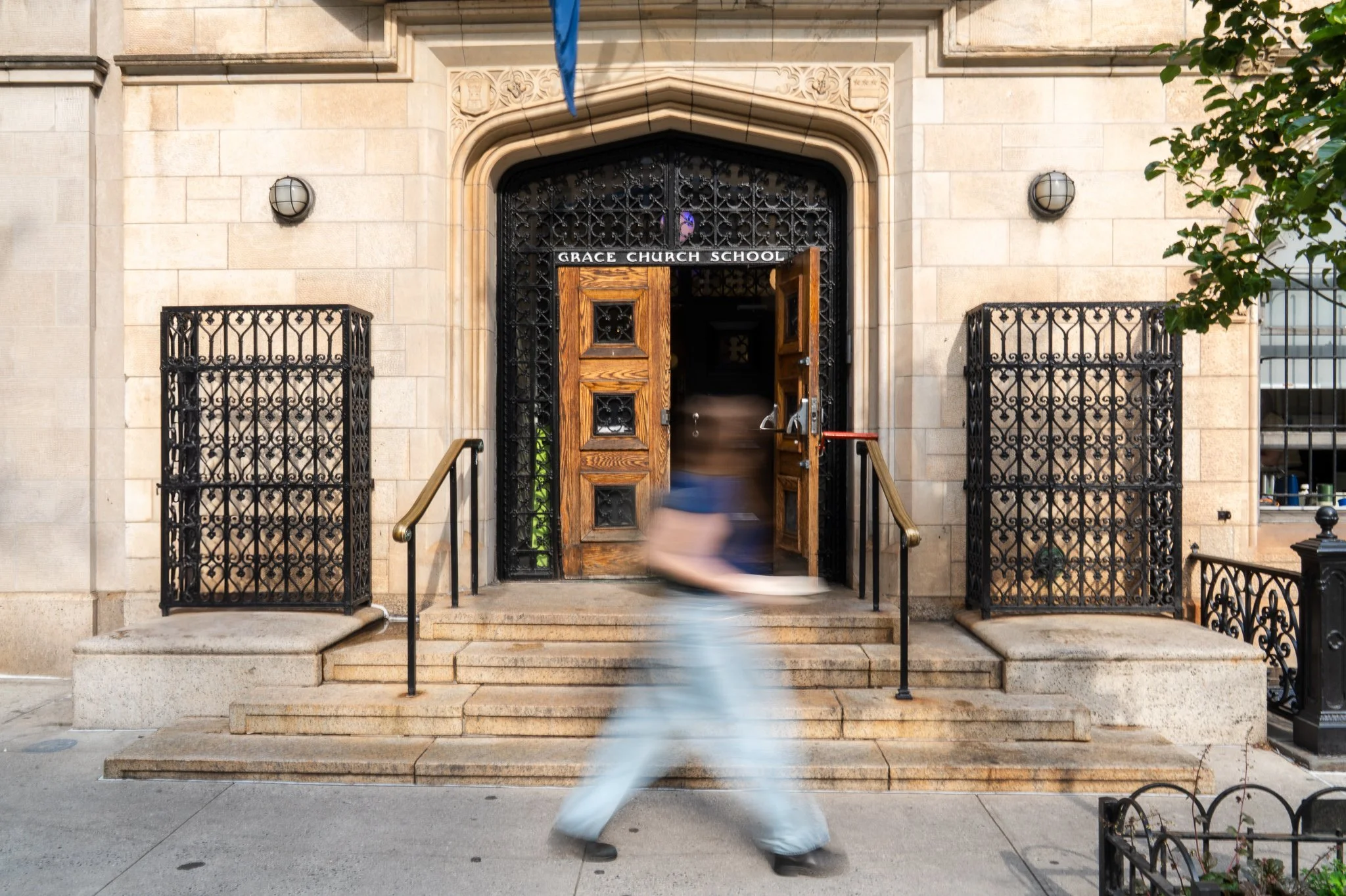 Blurred person walking past the entrance of Grace Church School