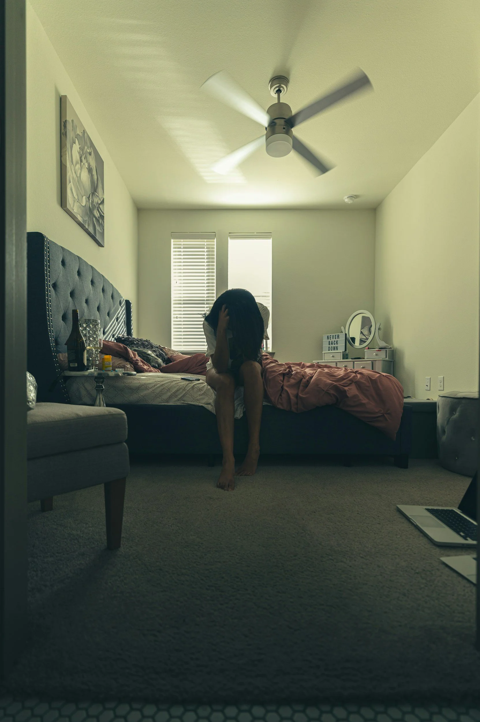 A woman sitting in despair on the edge of her bed feeling overwhelmed from the pressures of life, which will significantly lift after the Connect & Reset Group at Francis Psychotherapy