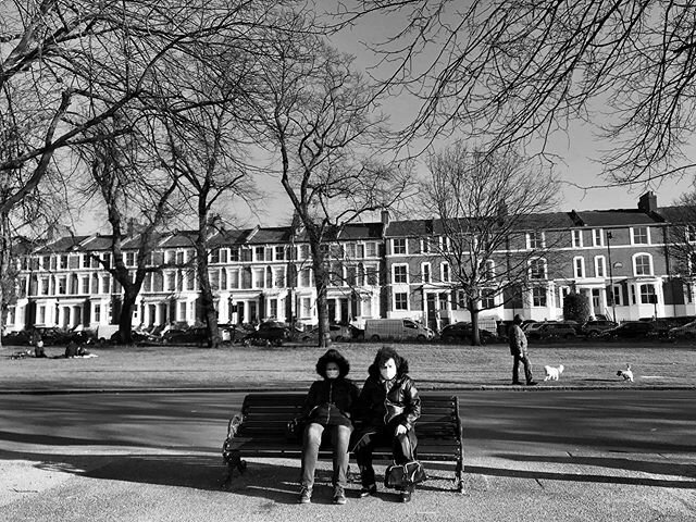 A couple are seen wearing masks seated in Victoria park which is now closed off to the public due to the global pandemic covid 19 crisis.  #shotoniphone #virus #london #victoriapark #news #love #besafe