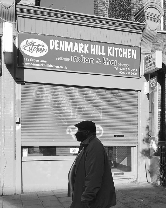 A man wearing a mask, walks past a once thriving takeaway buisness, now closed in the local area of Denmark hill in London. #covid_19 #news #currentsituation #blackandwhite #england #crisis #protectyourself #reportage