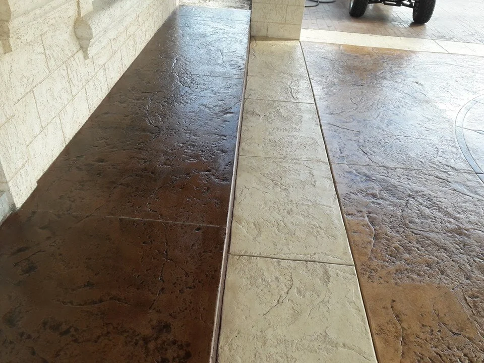 Textured concrete walkway with a decorative strip and different colored sections.