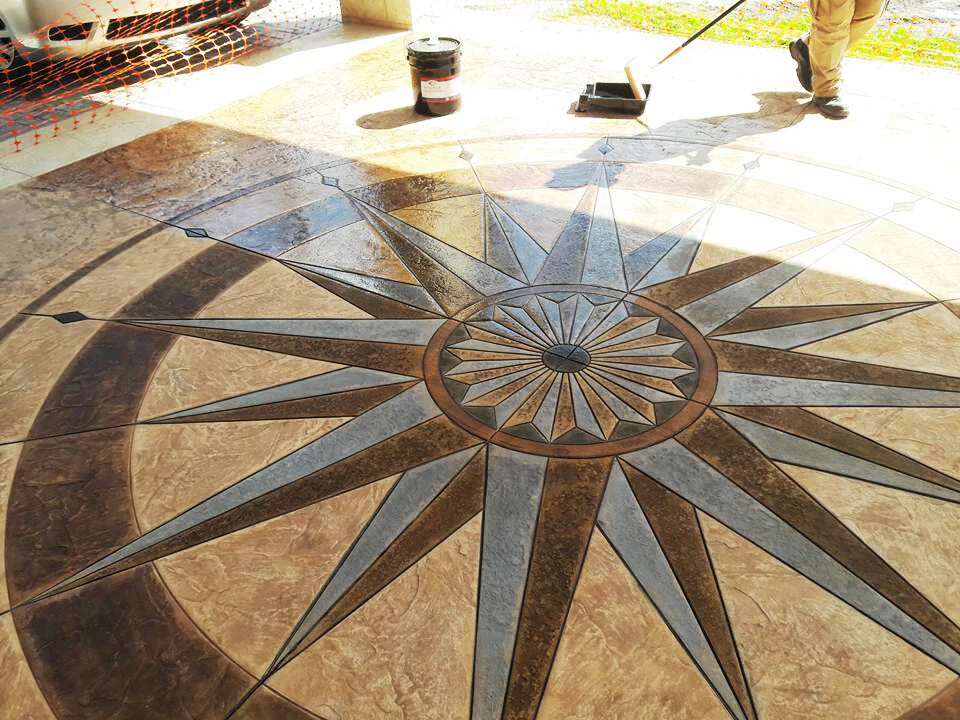 Decorative compass rose design on a concrete driveway being sealed