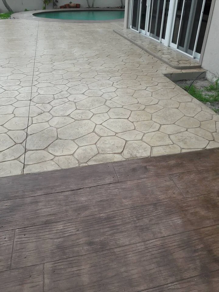 Patio area with hexagonal tiles leading to a swimming pool and sliding glass doors.