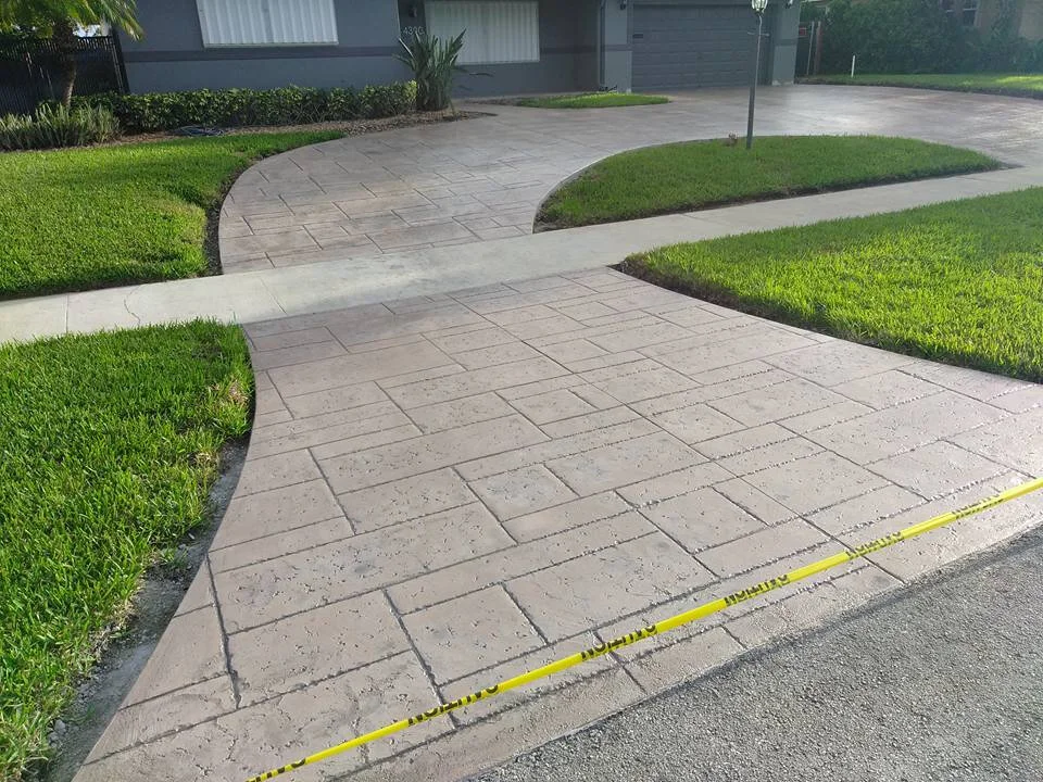 Stamped concrete driveway with pathway and green grass