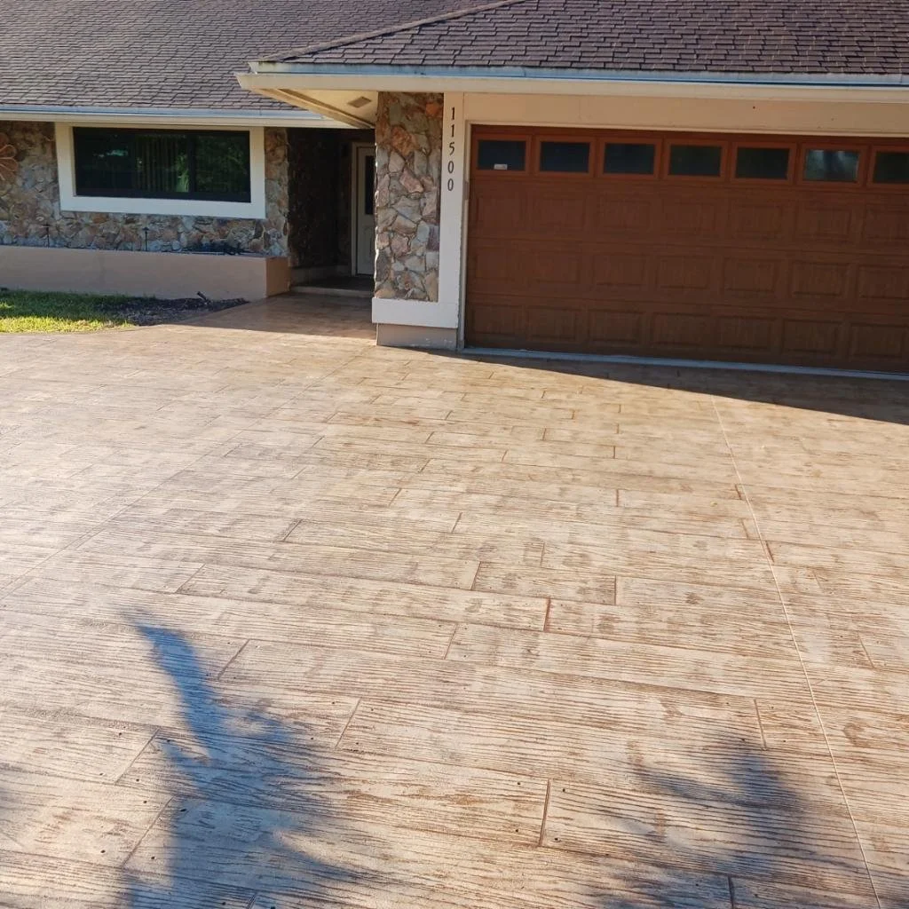 Front view of a house showing a stone exterior wall, large garage door, and a driveway.