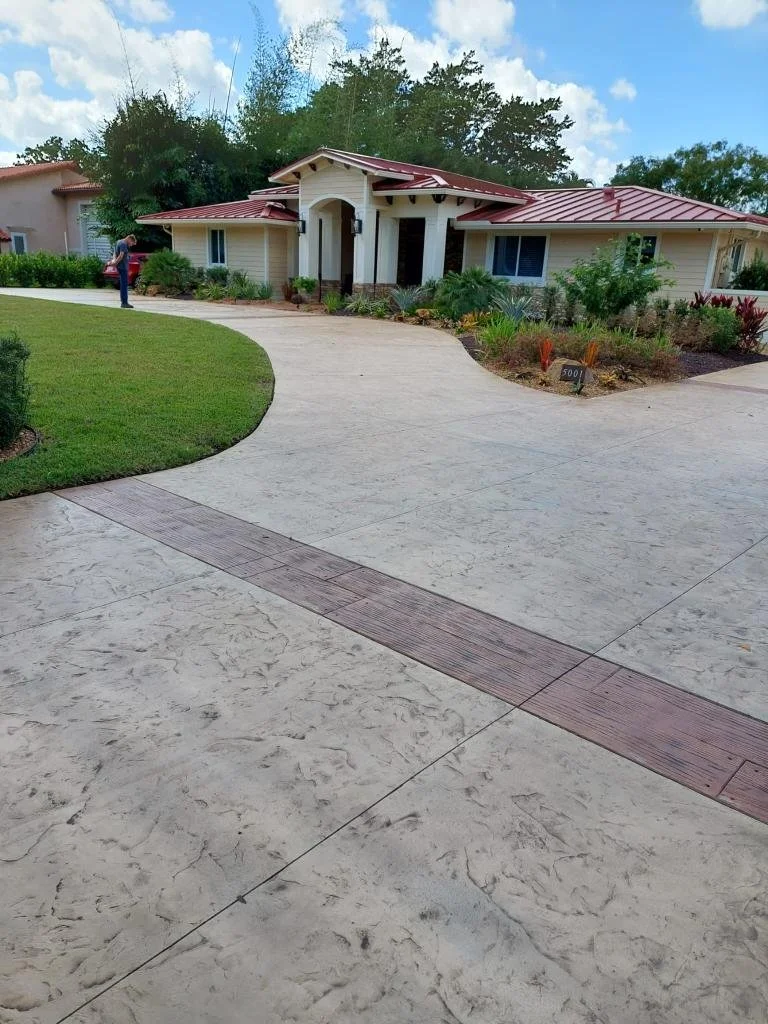 Single-story house with red metal roof and landscaped yard.