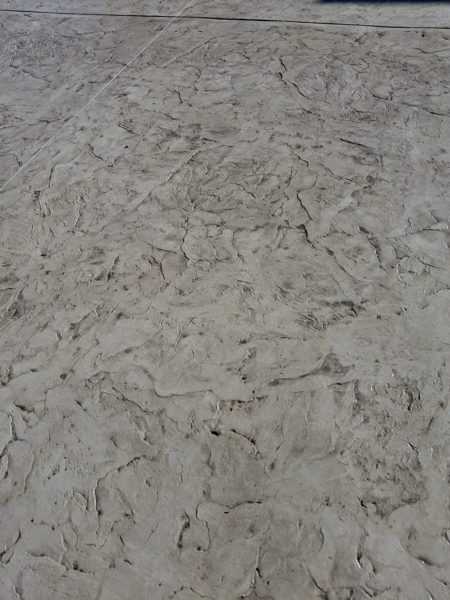Close-up of textured concrete floor with a stamped stone appearance.