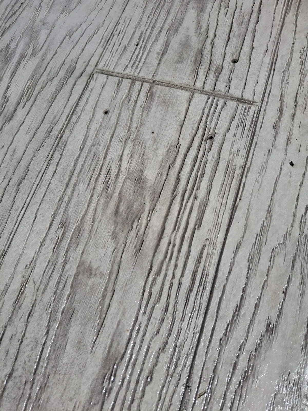 Close-up of a textured wooden surface with visible grain patterns and grooves.