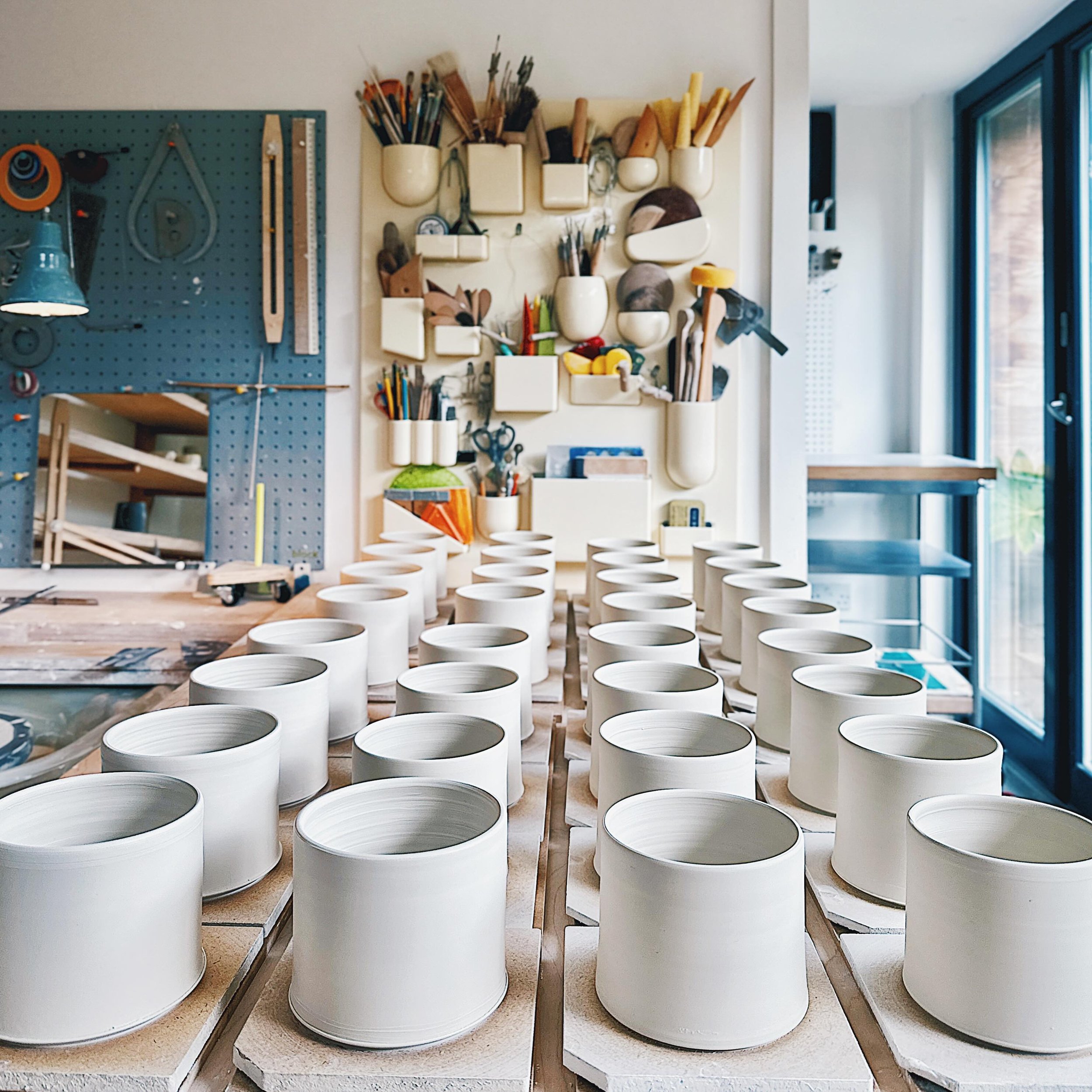 Studio table full of mug bodies ready to be turned 
.
.
.
.

#handmade #wheelthrown #porcelain #slipware  #pottery #clay #bythelinepottery  #porcelainpottery #urbanpotter #modernceramics #studiopotter  #maker #contemporaryceramics  #functionalceramic