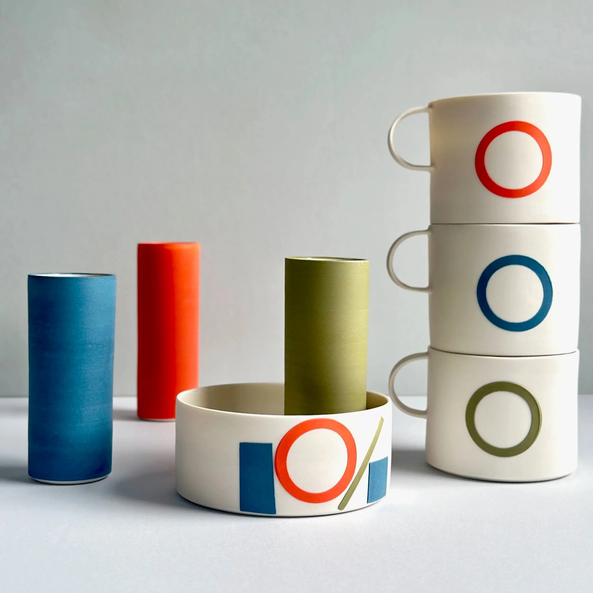 Slipware collection. Coloured porcelain slip applied to the white porcelain body using a variety of techniques such as hand cut paper stencils, solid colour, coloured rims and inlaid patterns.