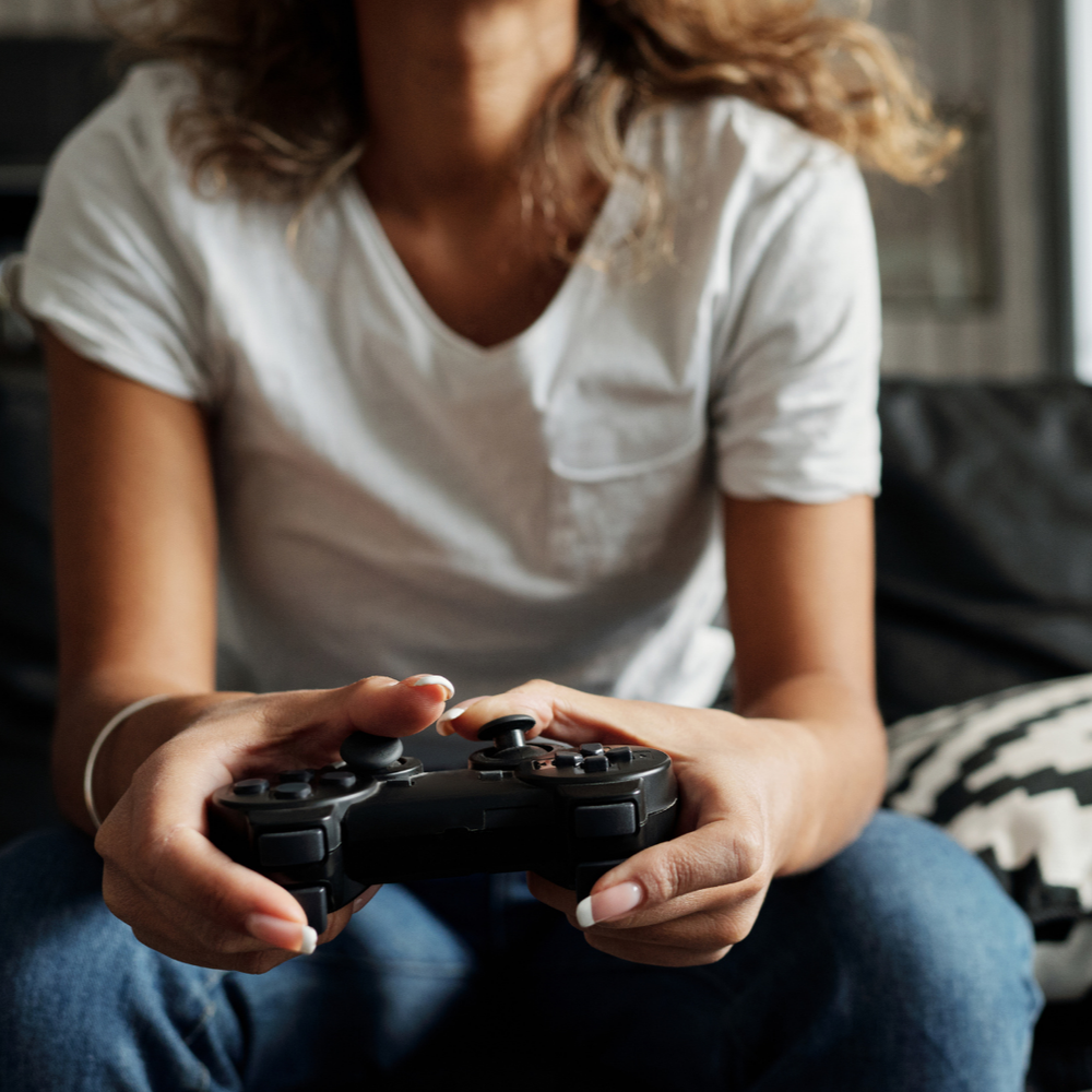 A person with long hair playing on an XBox