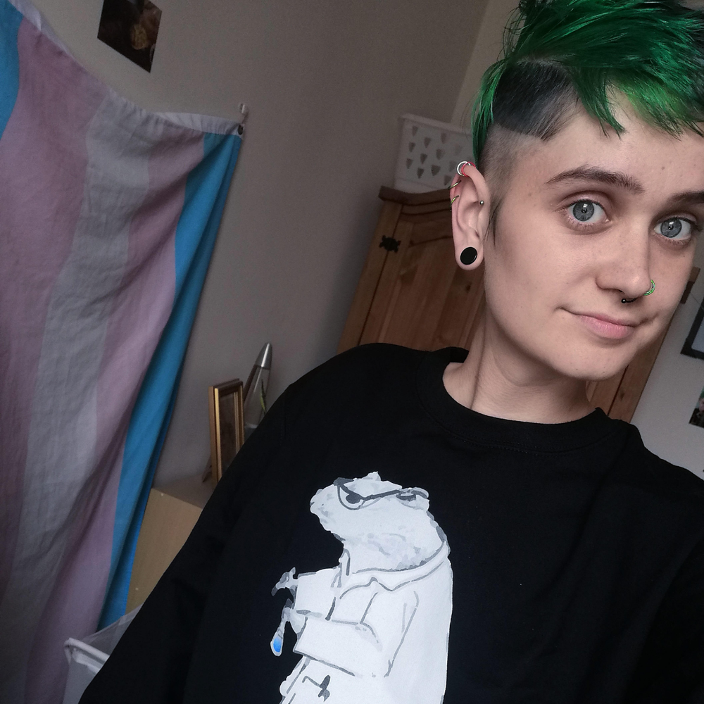 Gage, a non-binary person with short green hair
