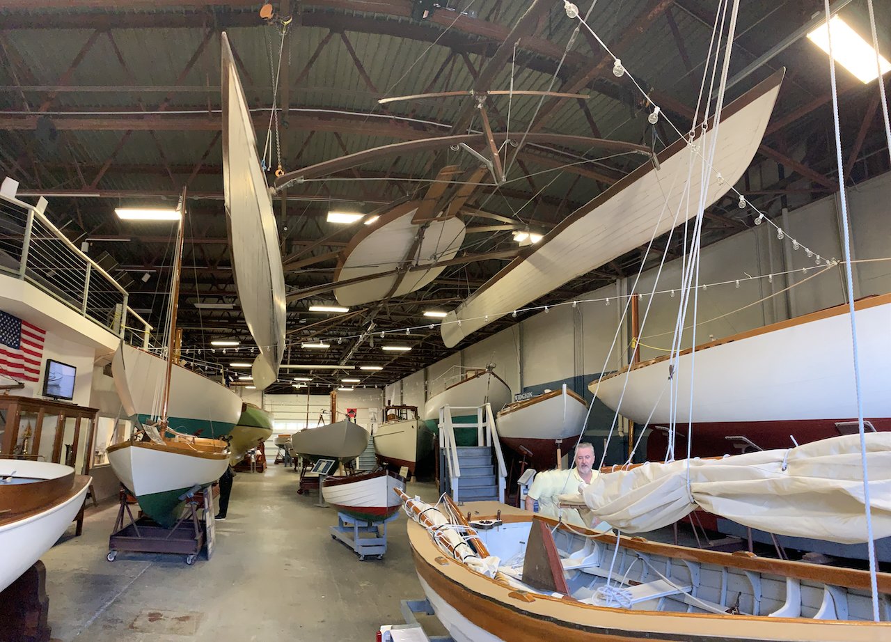 Floor level at HMM, Capt' Nat's classic keelboats; the 1870s multihull ,Amaryllis, first of its kind in America, hangs from the ceiling