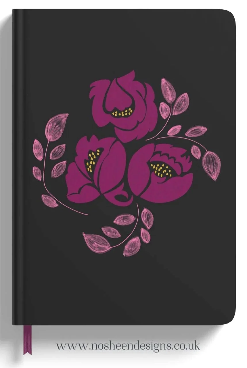 Black journal or planner with a pink floral illustration of three large flowers and pink leaves on the cover.