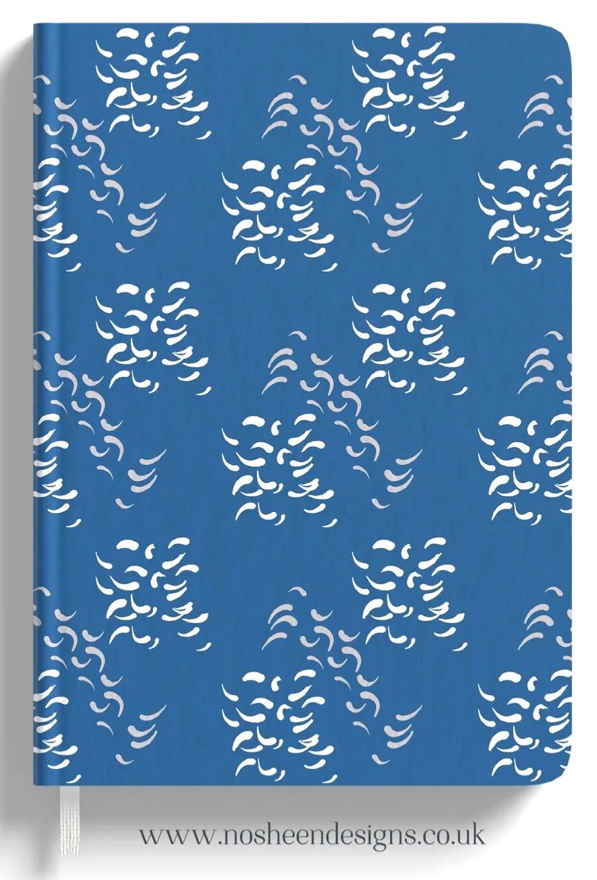 Blue notebook with white abstract patterns and the website www.nosheendesigns.co.uk at the bottom.