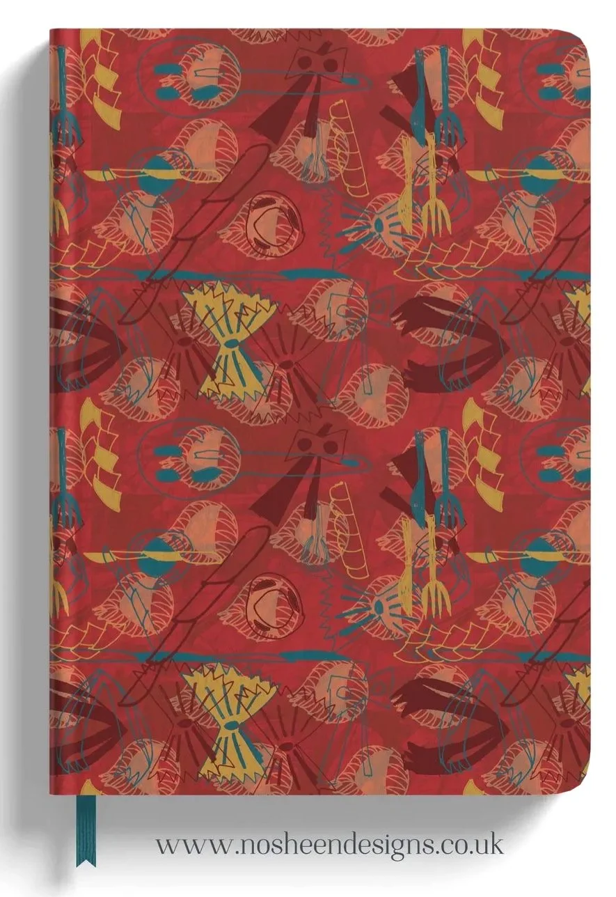 A red patterned notebook or journal cover with abstract designs in yellow, blue, dark red, and black, featuring elements that resemble bubbles, lines, and abstract shapes, with a blue bookmark ribbon at the bottom. The website www.nosheendesigns.co.uk is printed at the bottom.
