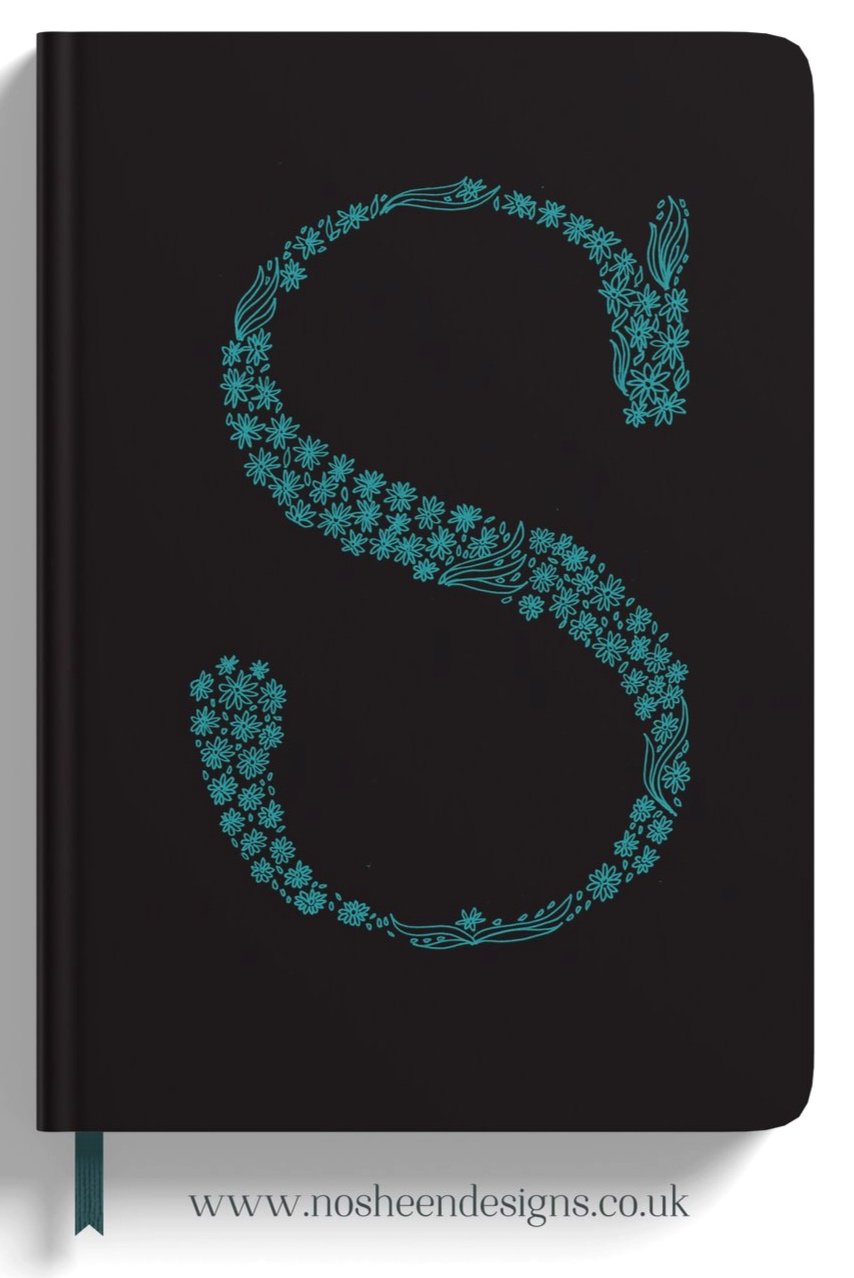 A black notebook cover with a large number 8 made of blue flowers and leaves, and the website www.noshendesigns.co.uk printed at the bottom.