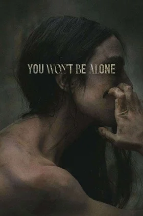 Movie poster for You Won’t Be Alone, faded grey, with the head and shoulders of the naked lead female character (a white woman with dark hair) crouched with dirty, long-nailed hands clawing at her cheek.