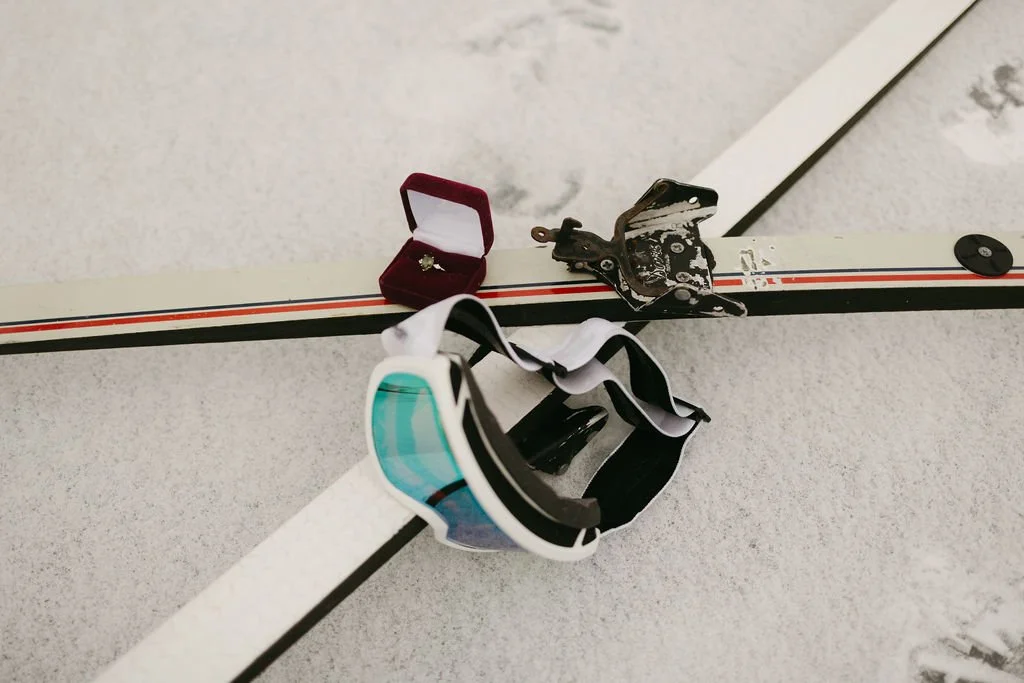 A diamond engagement ring sits atop skis during a surprise proposal in Breckenridge, CO