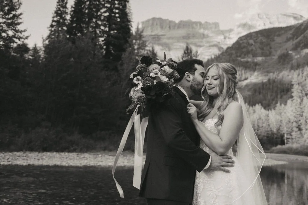 A bride and groom embrace following their private vow exchange at Logan Creek in Glacier National Park.
