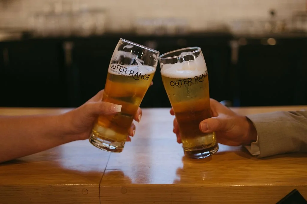 A bride and groom sip beers at Outer Range following their intimate wedding ceremony.