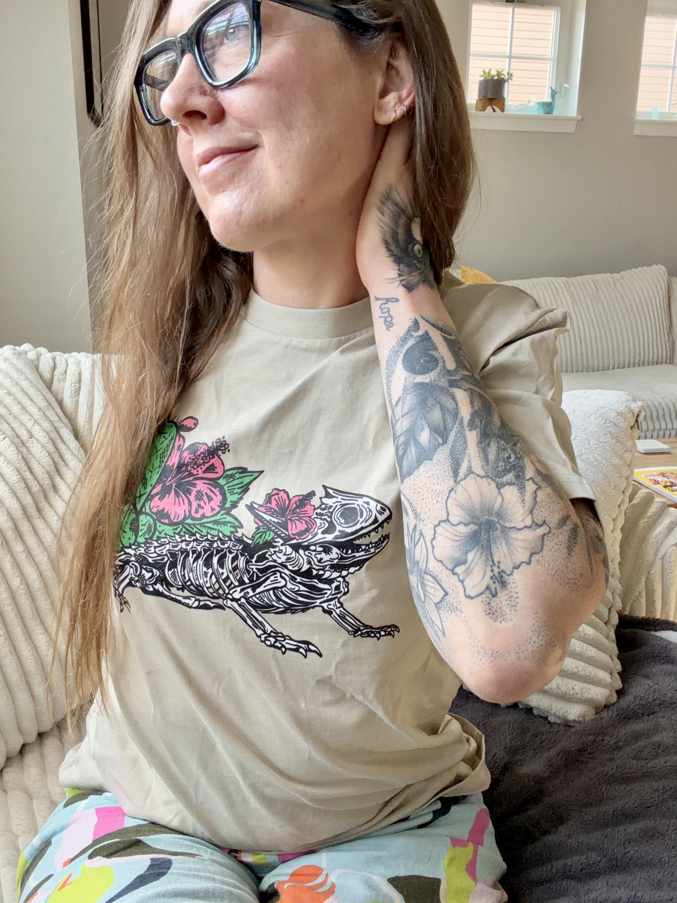 Tattooed woman with t-shirt design of lizard skeleton designed for Texas Eclipse Outfitters.
