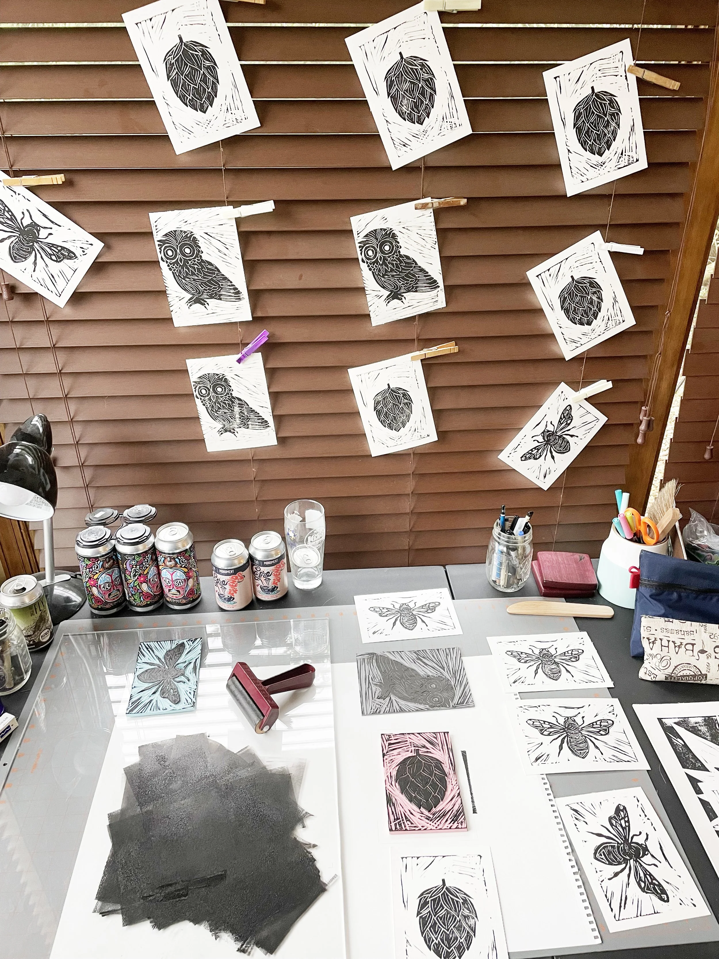 Lino print making process showing ink and prints hanging to dry.
