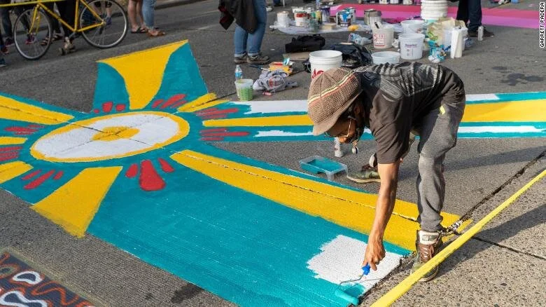 Local artists collaborate to paint a giant Black Lives Matter mural on the street