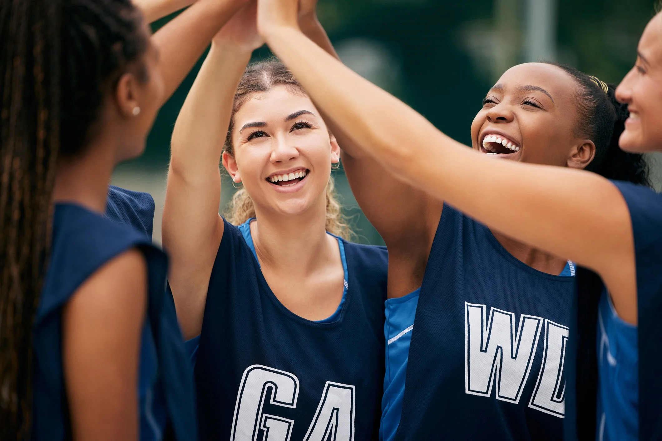 Netballers high fiving at netball competition