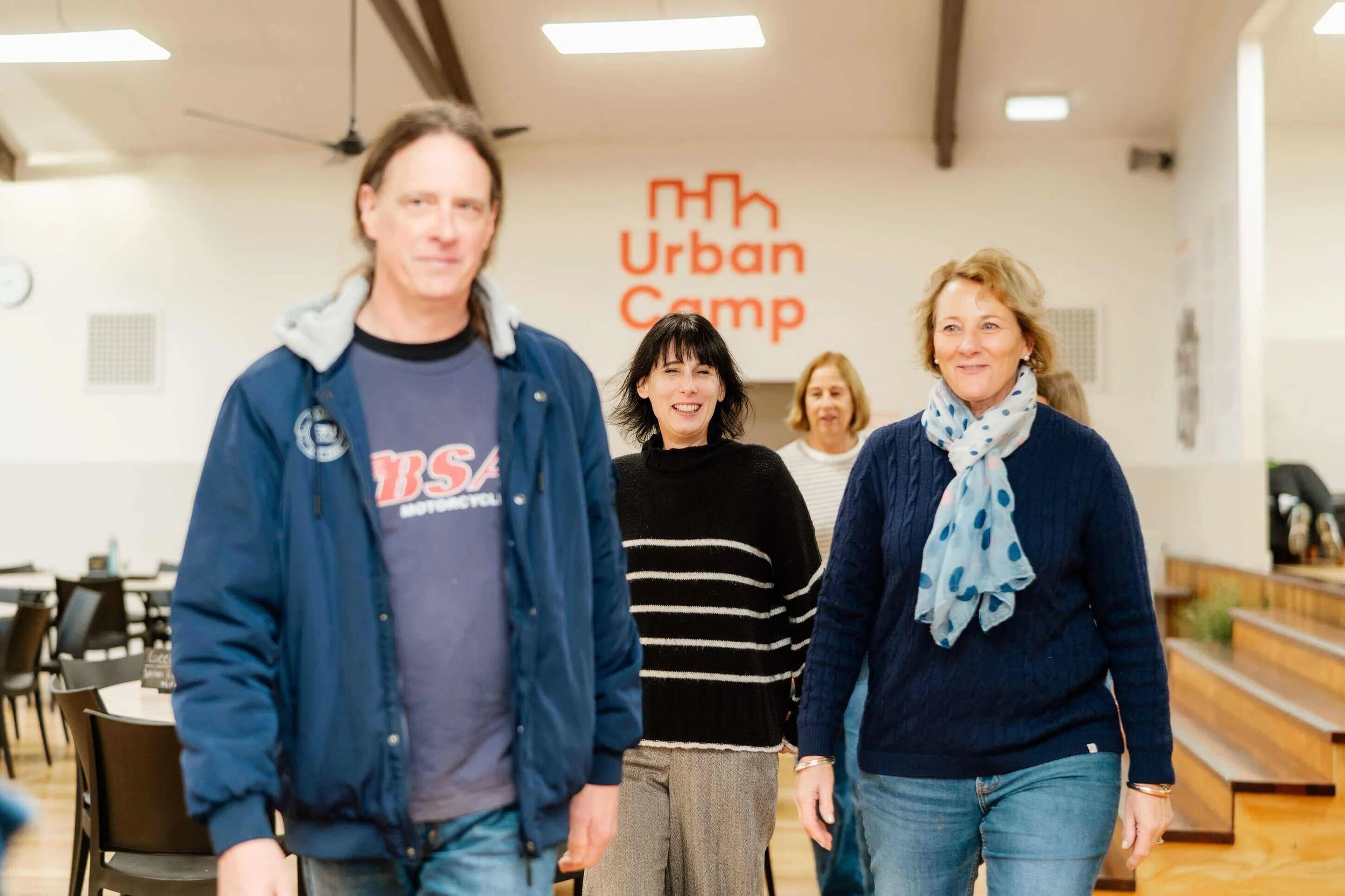 Adults walking inside ANZAC Hall at Urban Camp.
