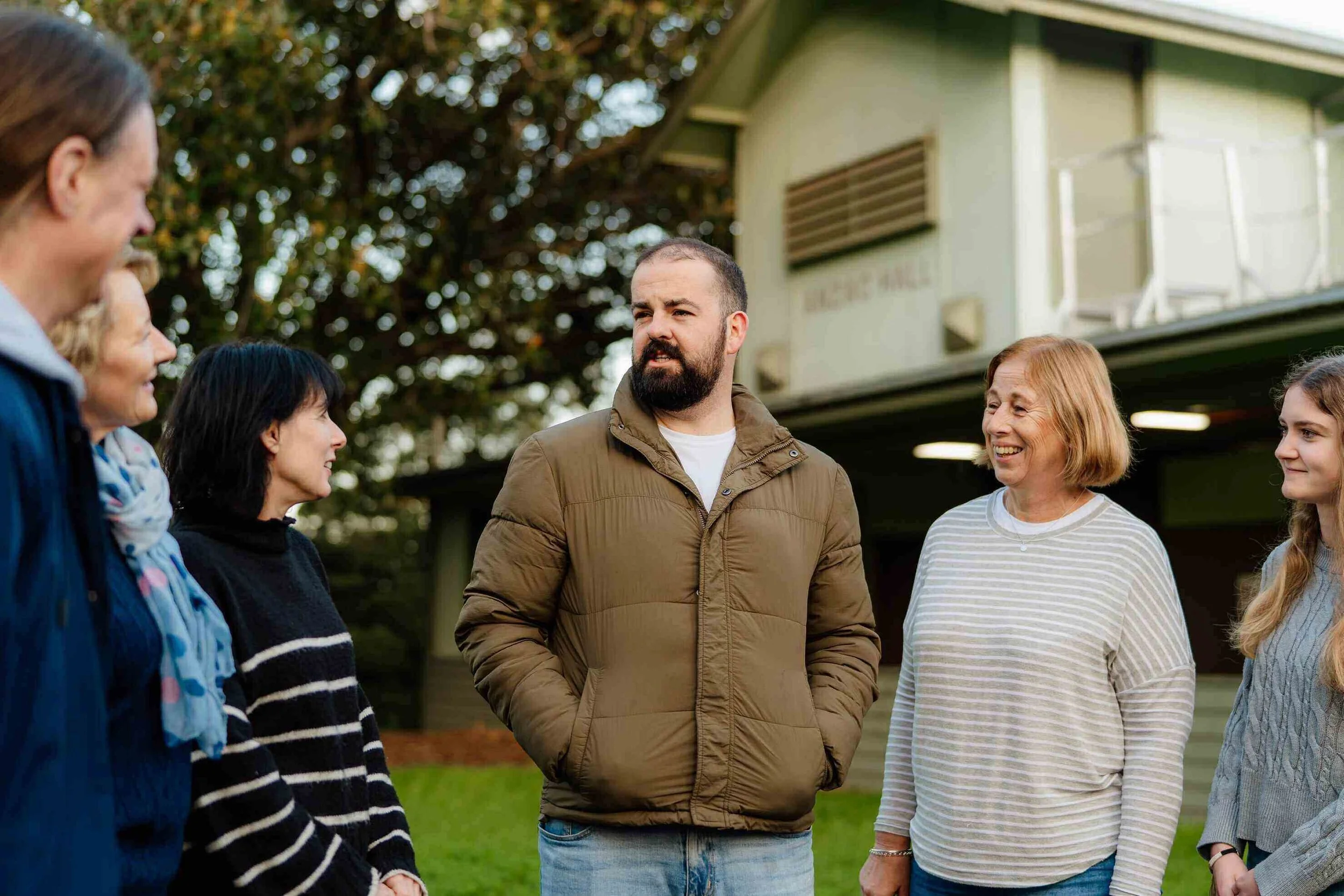 Adults standing outside ANZAC Hall at Urban Camp.