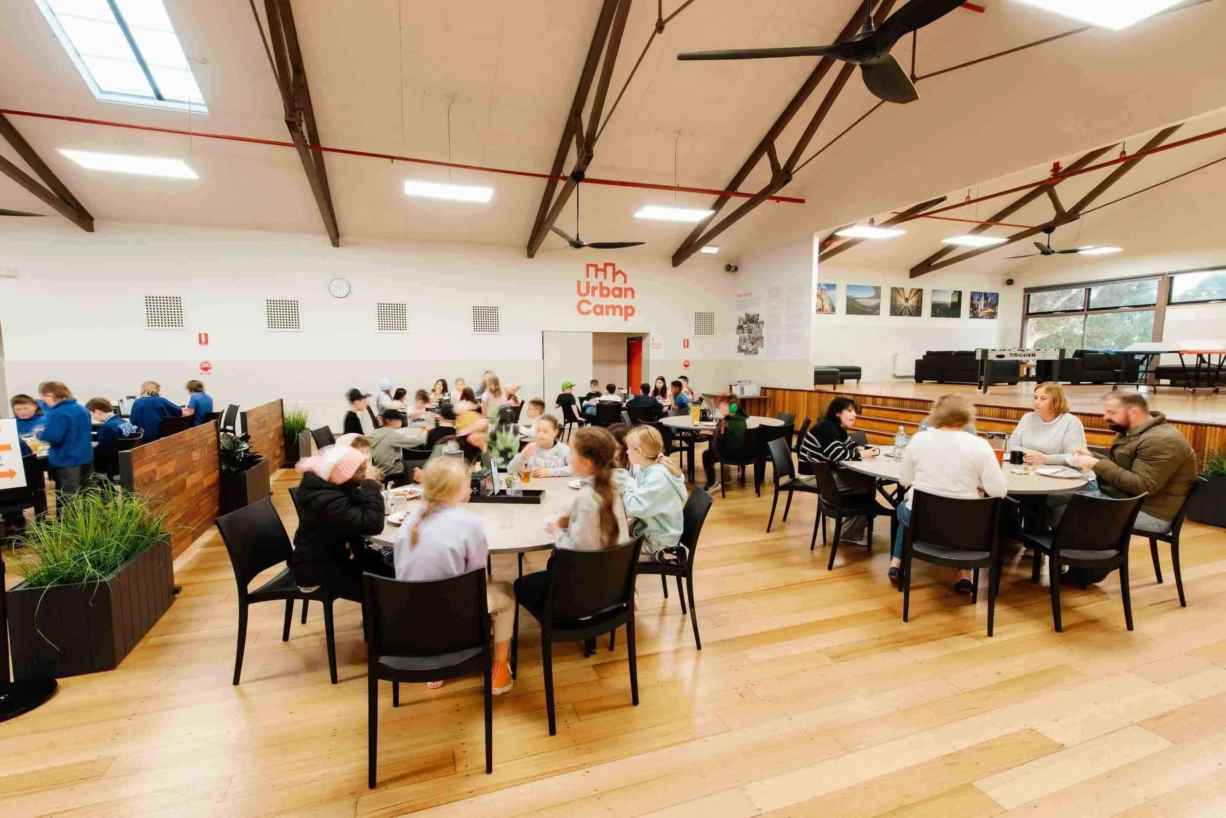 Students eating at round tables in ANZAC Hall at Urban Camp.