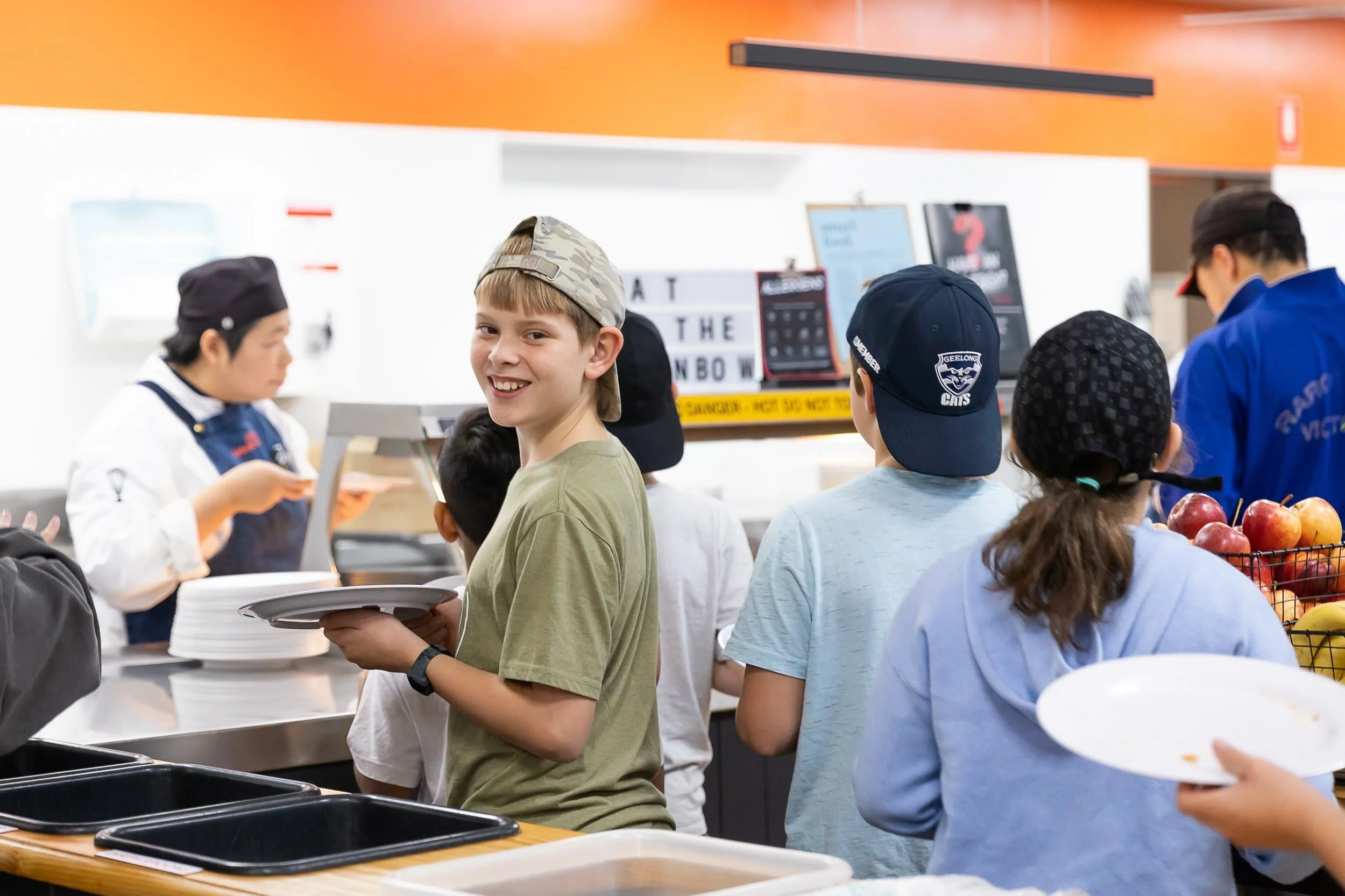 Child lining up for dinner service at Urban Camp.