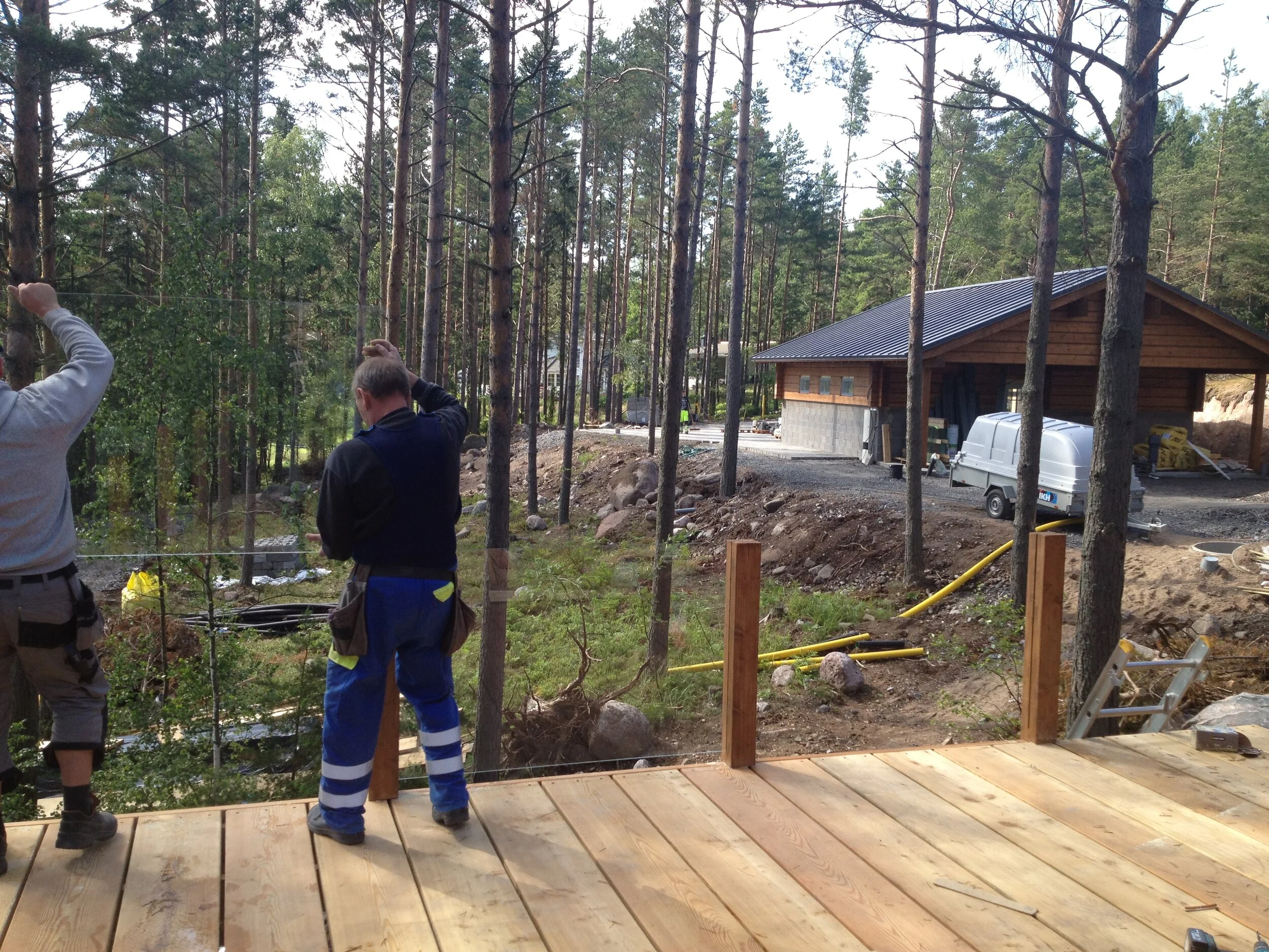 Terassin kaidelasien asennus puusepän urittamien tolppien väliin käynnissä