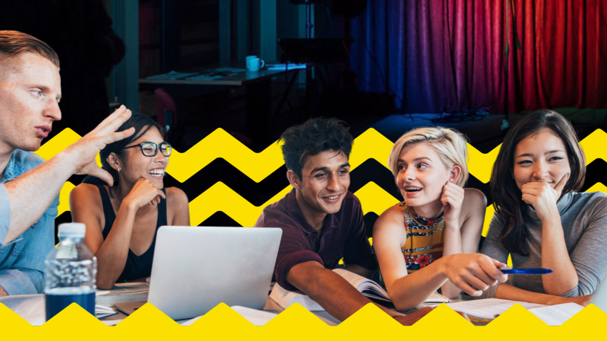 Group of young people working as a group around a table with laptop