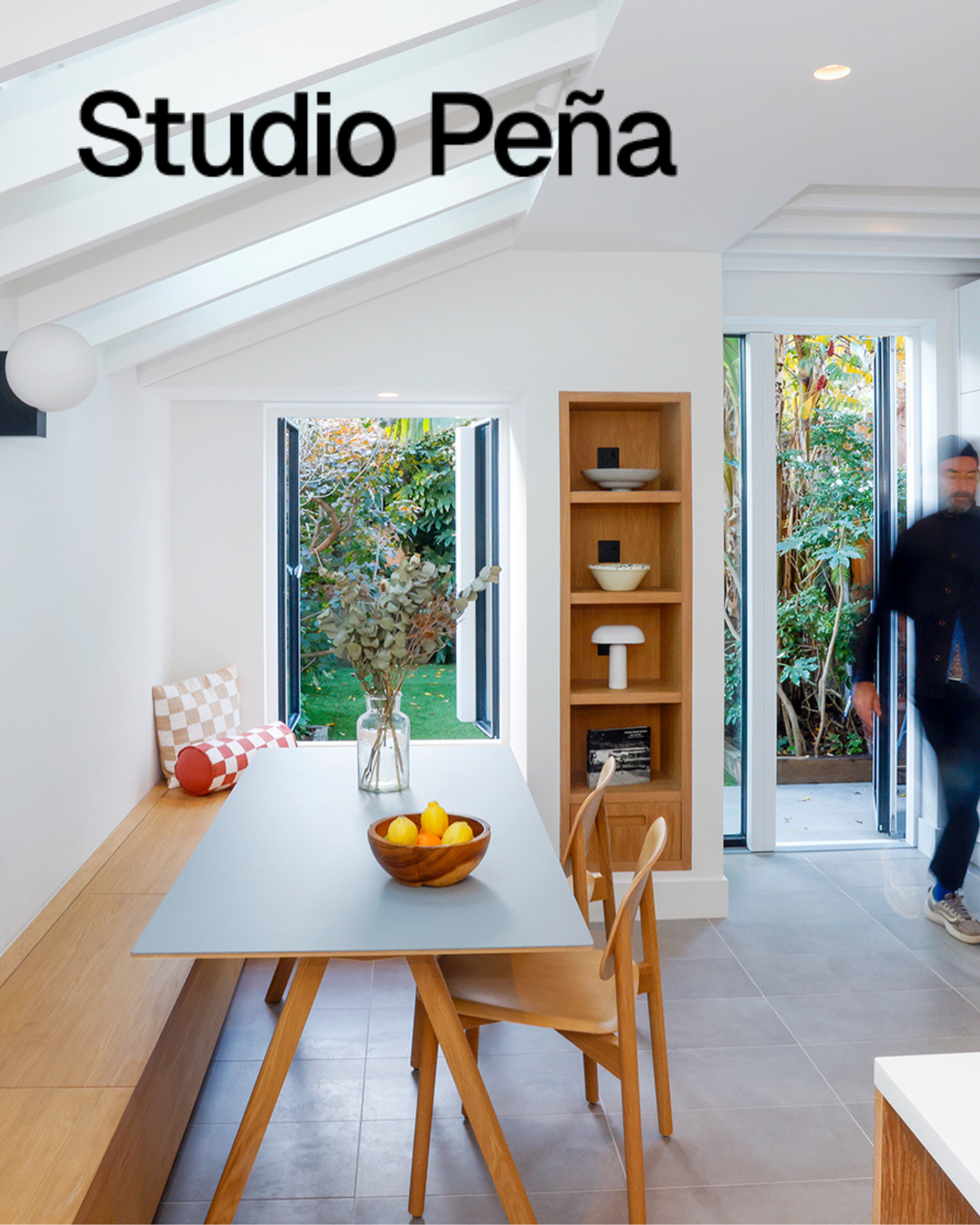 Light, bright kitchen diner with bench seating, a dining table and windows opening out to garden.