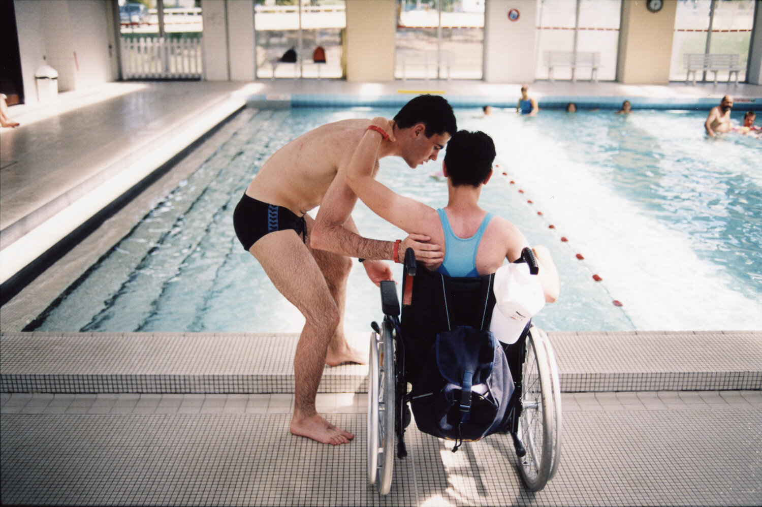  Un bénévole accompagne à la piscine une personne en situation de handicap. Avec APF France Handicap. Talence, France. Août 2004 // A volunteer accompanies a person with a handicap to the swimming pool. With APF France Handicap. Talence, France. Augu