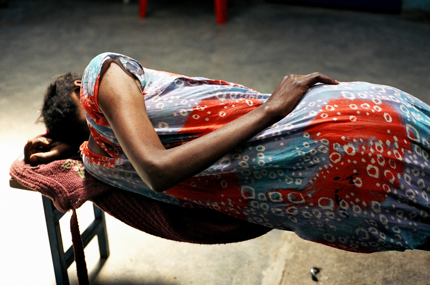  Une femme dort sur un banc de la salle d'attente de la clinique SIDA du bidonville de Matharé. Les temps d'attente sont très longs : MSF procède à plus de 100 consultations par jour. Avec Médecins Sans Frontières, dans la lutte pour l'accès aux médi
