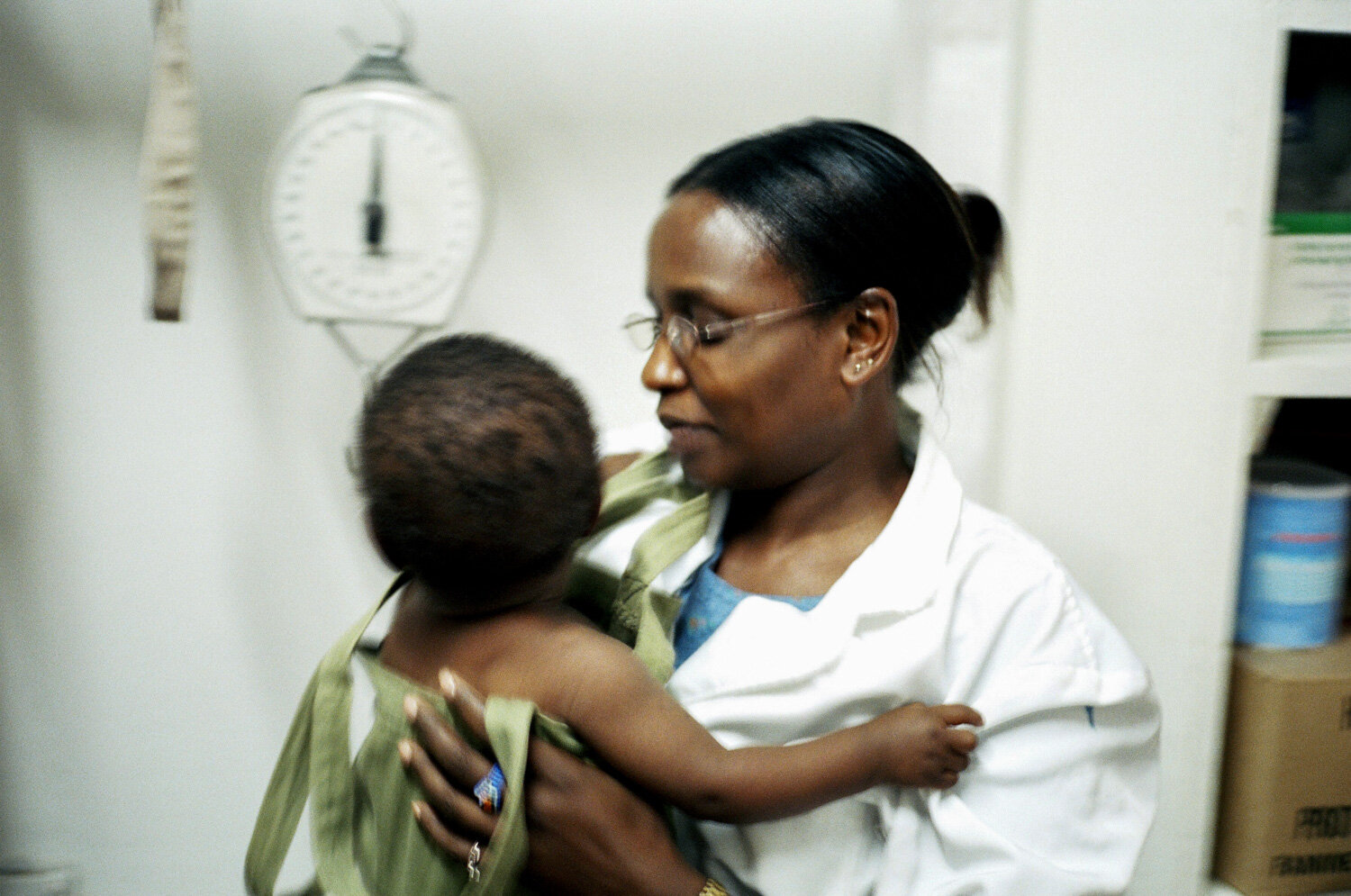  Une infirmière vient de peser un enfant, elle va donner à sa mère des conseils en nutrition. Dans la clinique SIDA du bidonville de Matharé. Avec Médecins Sans Frontières, dans la lutte pour l'accès aux médicaments essentiels. Nairobi, Kenya. Mars 2