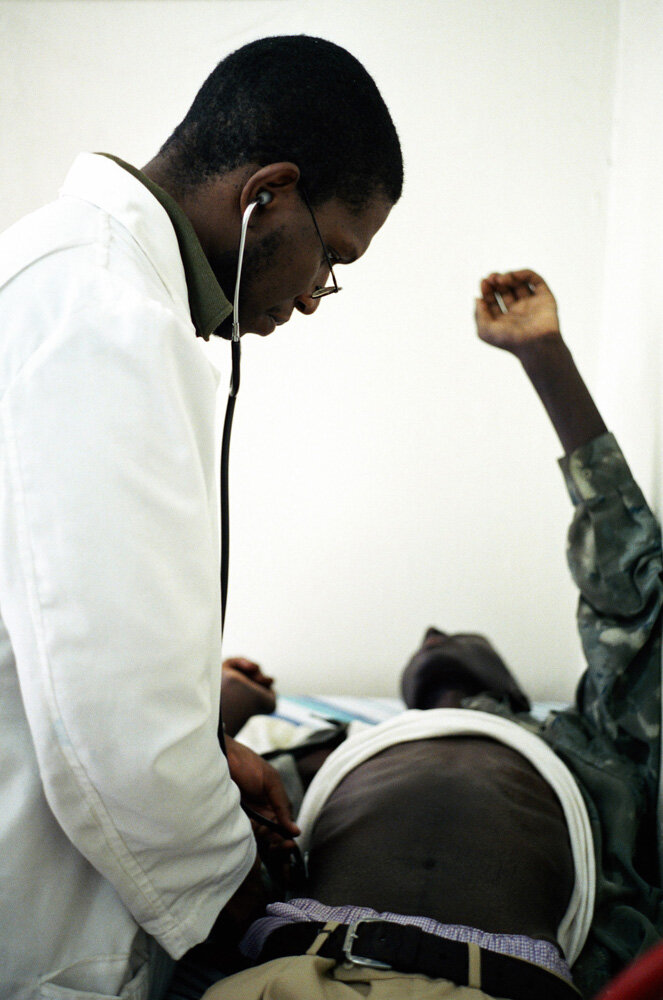  Un médecin examine le mari dans la clinique SIDA du bidonville de Matharé. Avec Médecins Sans Frontières, dans la lutte pour l'accès aux médicaments essentiels. Nairobi, Kenya. Mars 2005 // A doctor examines the husband in the AIDS clinic in the slu