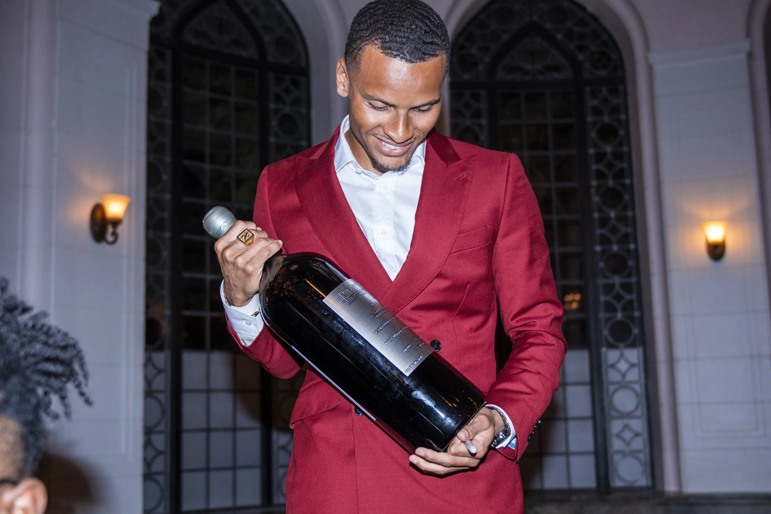 Andre De Grasse admires his new limited edition, 19.62 wine, name inspired after his Olympic 200m gold medal race time, at the launch party at Casa Loma. September 20, 2022. (Kaj Larsen photo for Coolbet Canada)