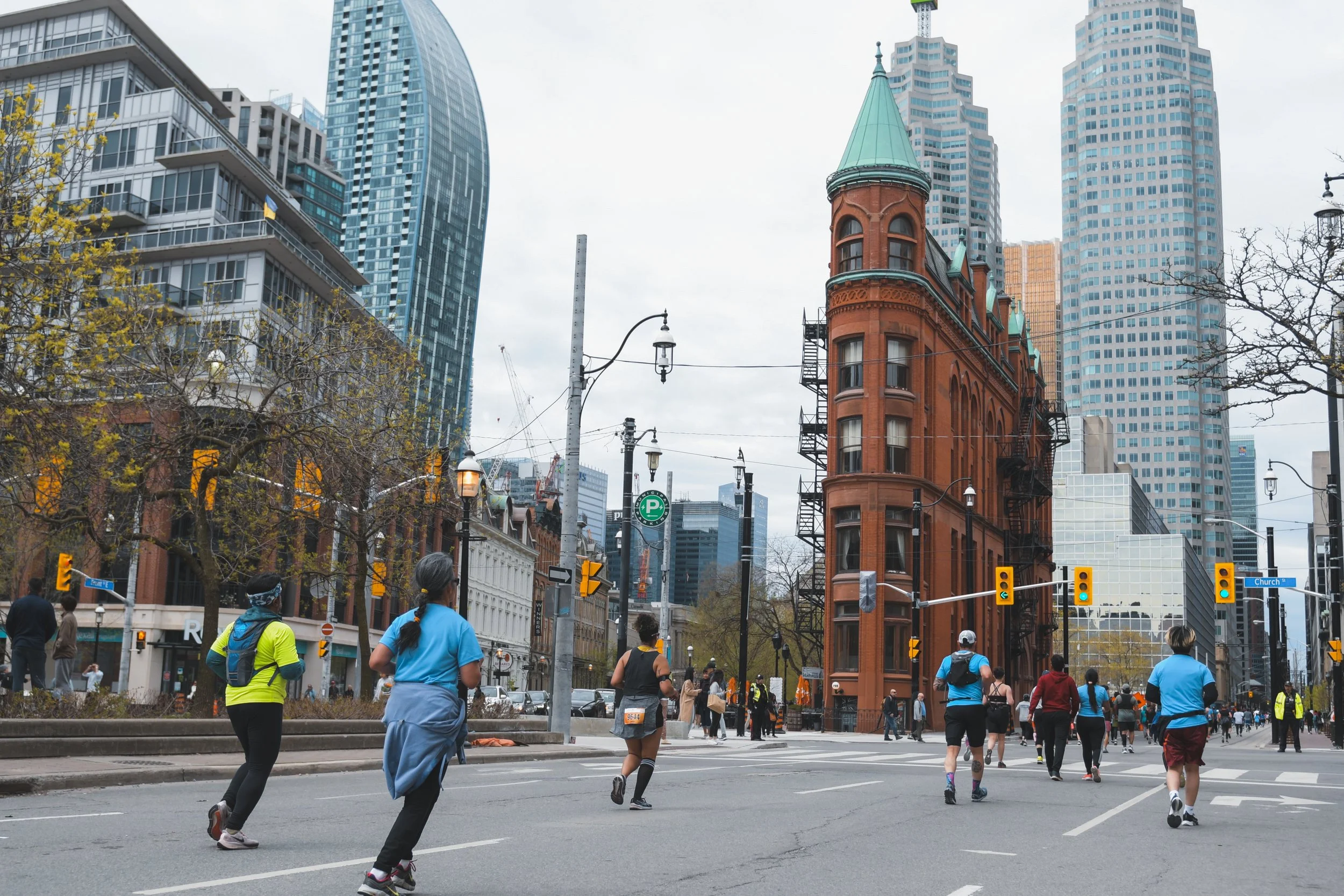 Runners pass by the Gooderham Building during the Toronto Marathon. May 7, 2023. (Kaj Larsen Photo for Marathonfoto/Toronto Marathon)