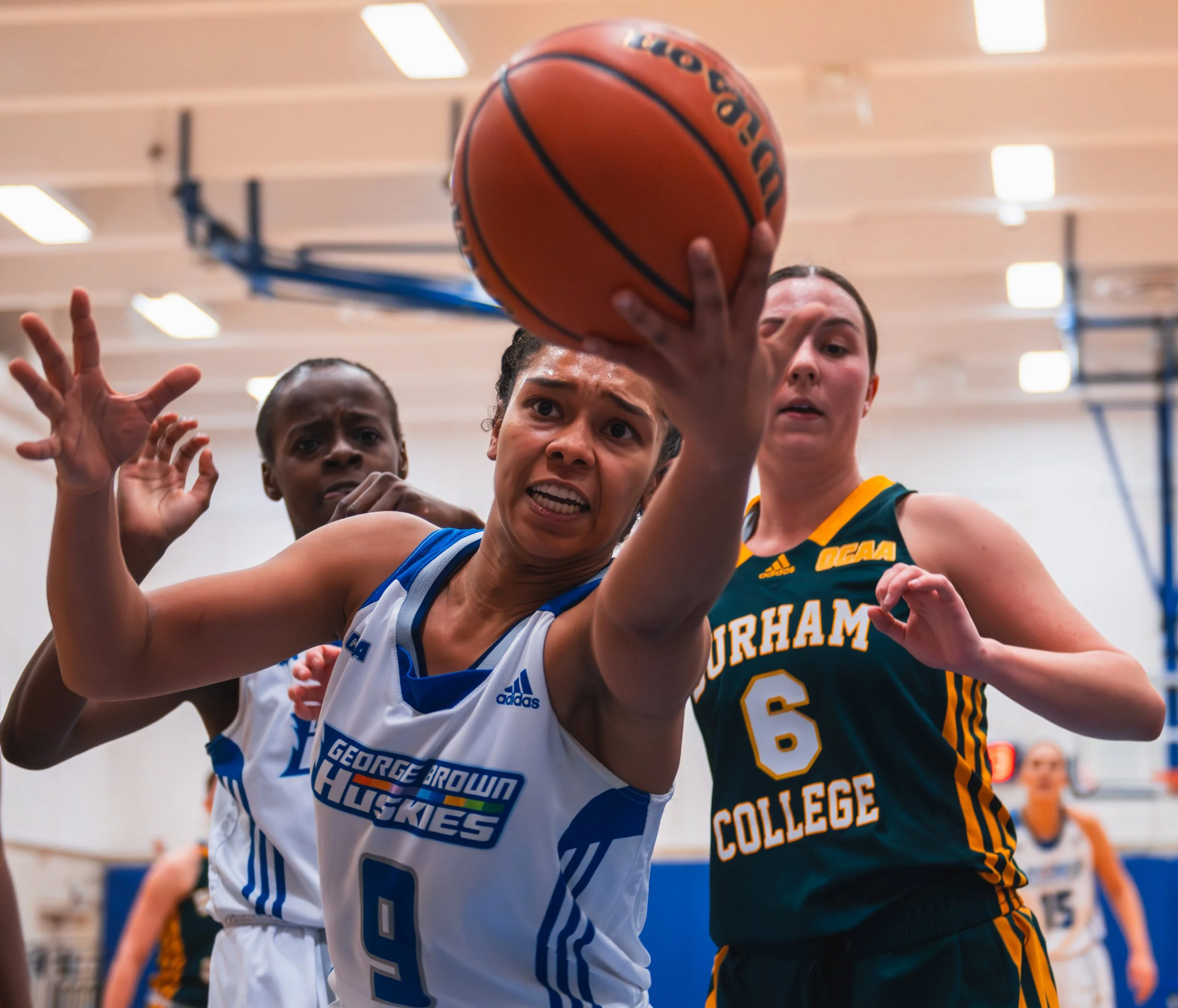 George Brown Huskie Meeko Thomas keeps a ball inbounds along the baseline vs. the Durham College Lords. February 25, 2022. (Kaj Larsen photo for George Brown College)