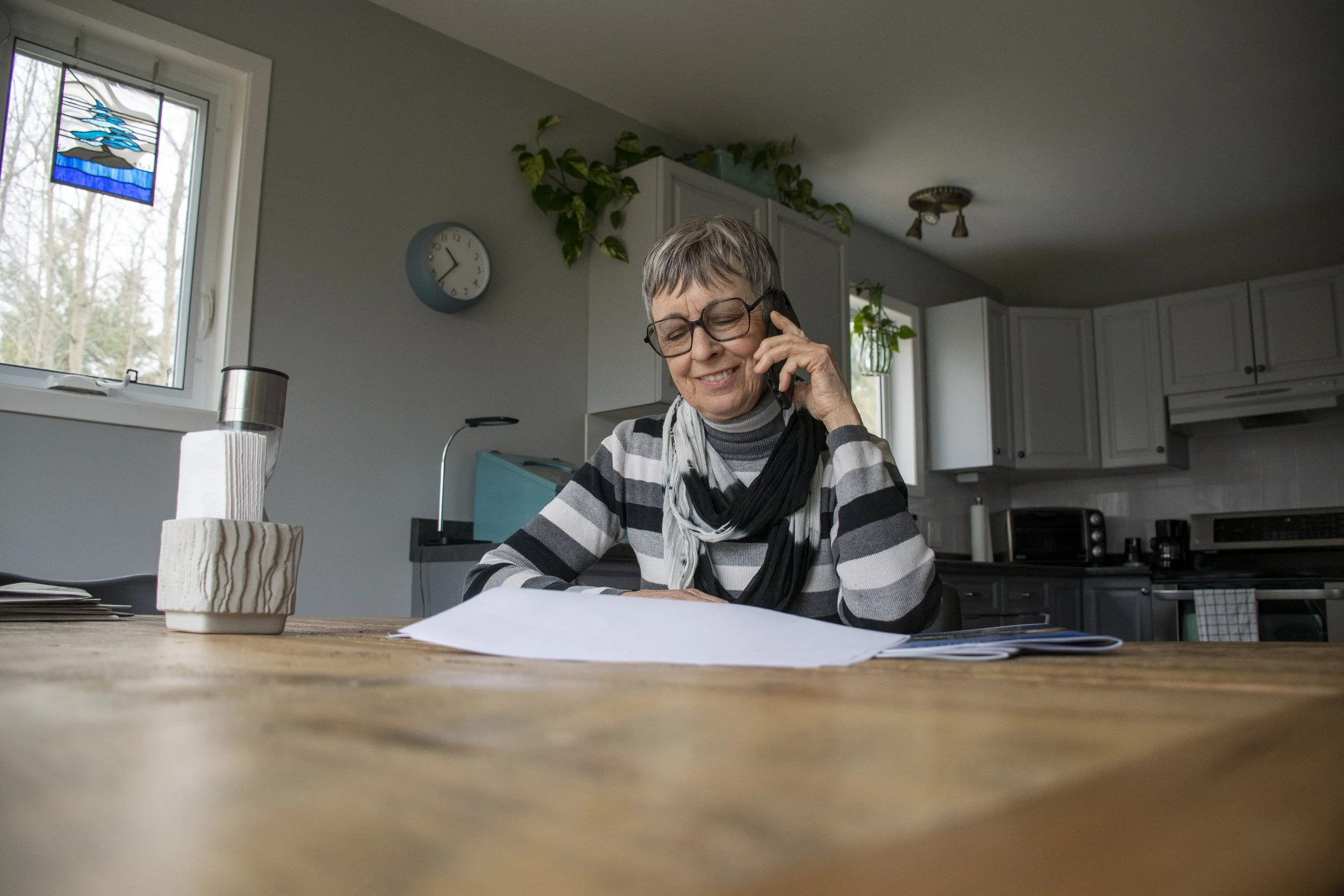 Carola calls her real estate broker whilst looking at housing listings, as she prepares to move from the countryside into the city of Cobourg. May 1, 2023. (Kaj Larsen photo for the Toronto Star)