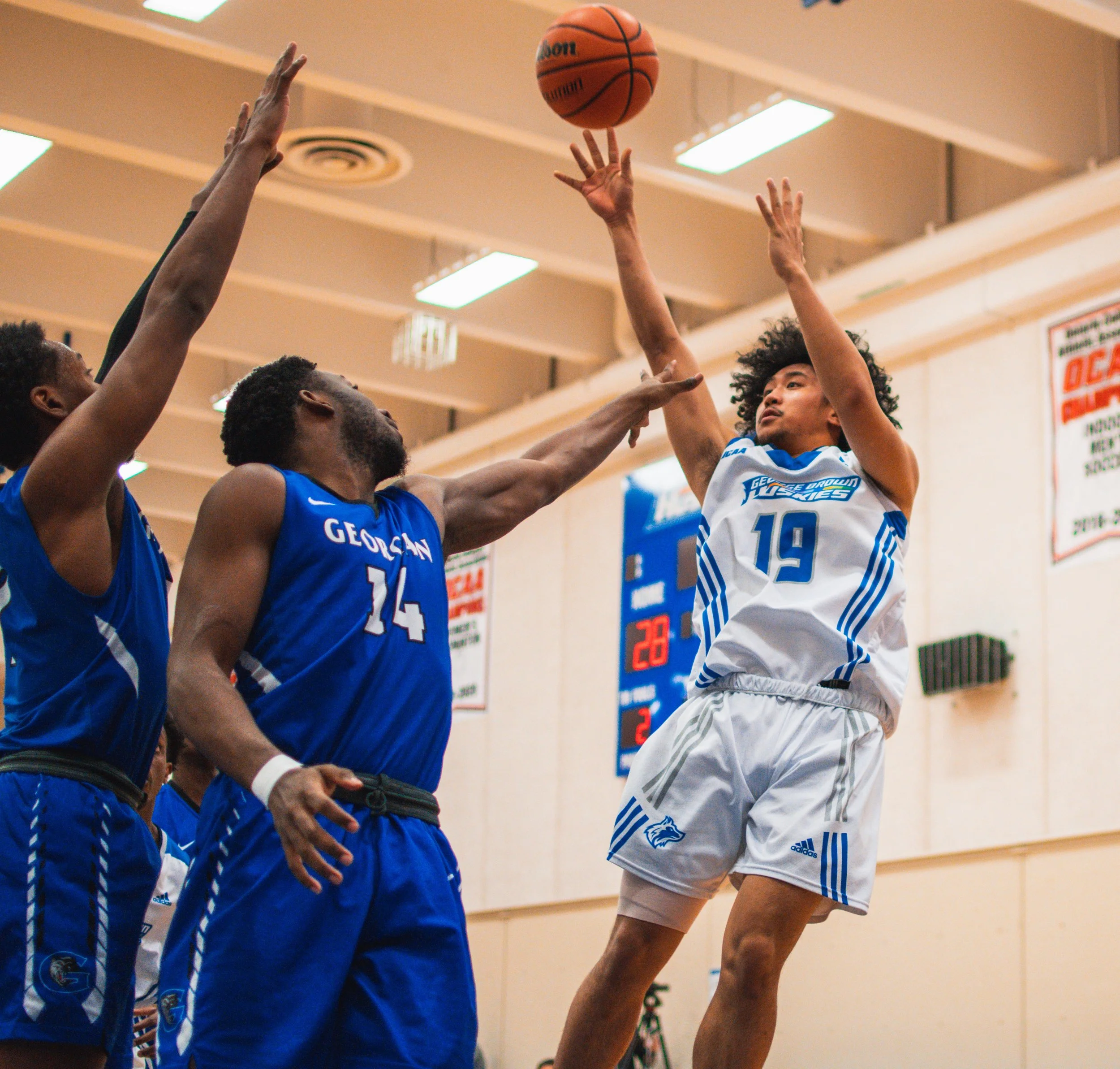 George Brown Huskie Patrick Rivera hits a fadeaway jump shot over two defenders. February 25, 2022. (Kaj Larsen photo for George Brown College)